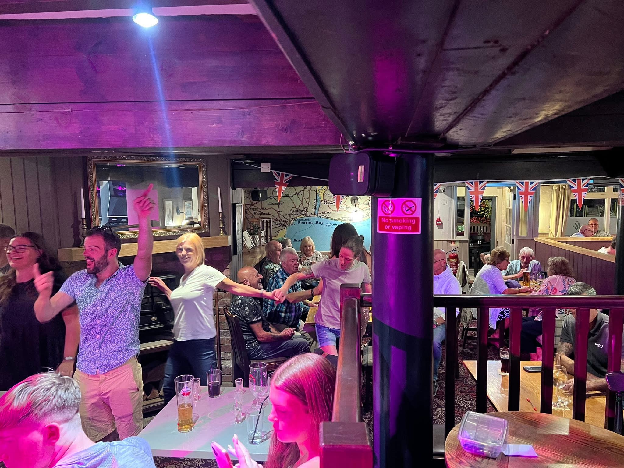 Guests singing and dancing together at a karaoke night.